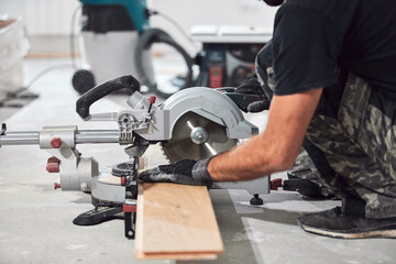 Professional handyman installing laminate flooring in a new apartment.