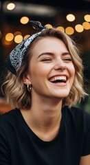 Fototapeta premium Woman with short hair and bandana smiles joyfully against a backdrop of warm lights in an outdoor setting