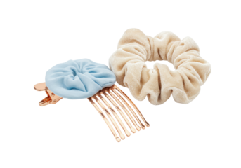 Isolated hair accessories, a light blue floral comb and a tan velvet scrunchie for styling hair