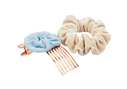 Isolated hair accessories, a light blue floral comb and a tan velvet scrunchie for styling hair