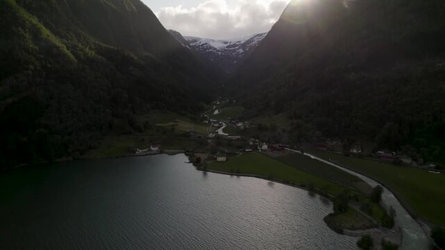 Aerial view of the breathtaking Odda valley, nestled between towering mountains with snow-capped peaks under a soft sky, Odda, Vestland, Norway.