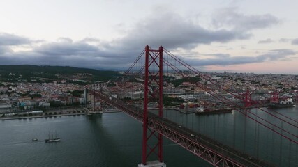 Aerial view in front of the 25th of April bridge on Tajo river, sunset in Lisbon