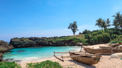 Traditional wooden fishing boats resting on a tropical beach with turquoise water, rocky cliffs, and bright blue sky, creating a calm and beautiful coastal scenery