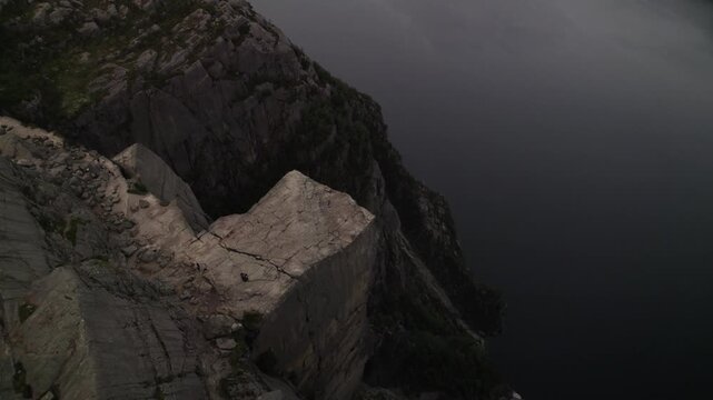 Aerial view of the dramatic Pulpit Rock's cliff rising above the dark waters, a stunning contrast of textures and tones, Songesand, Rogaland, Norway.