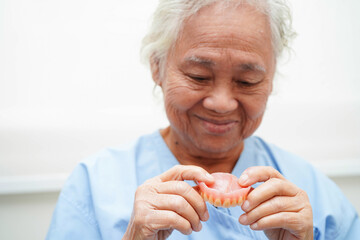 Doctor holding teeth denture in hand for dentist studying about dentistry.