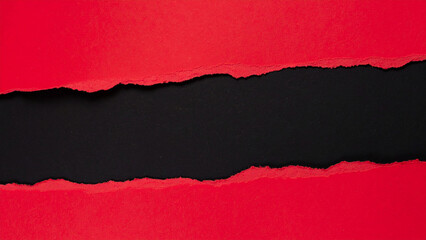 Torn red paper revealing black background in close-up view