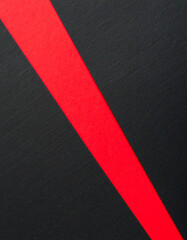 Torn black paper revealing red layer in diagonal composition