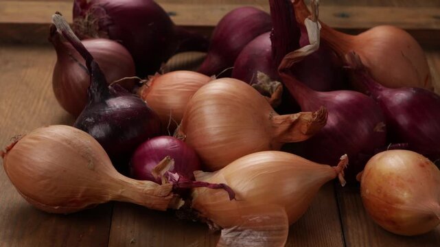 red and brown bulbs onios on wooden surface food close up zoom