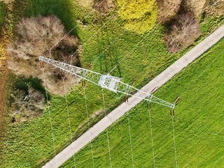 Aerial View of High Voltage Power Line Tower in Green Landscape