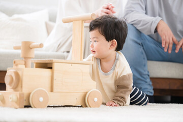 木のおA crawling baby playing with wooden toys