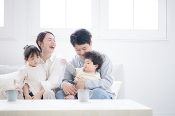 Fototapeta premium 笑いが絶えない幸せな仲良し家族の子育て・育児の日常 リビングでの子供のお世話