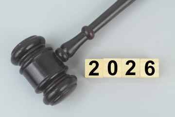 Wooden judge gavel and numbers 2026 on cubes on grey background. Legal system and laws in 2026 concept.	