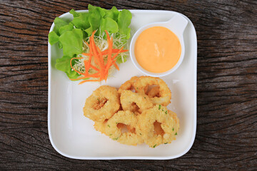 Breaded calamari with tartar sauce decorated on a black plate, Calamari with Herbal Tartar Sauce