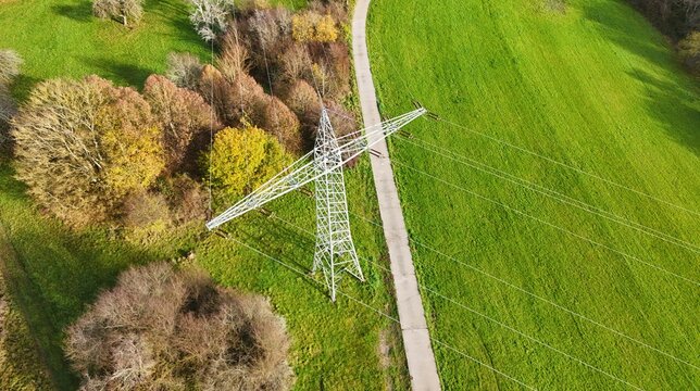 Aerial View of High Voltage Power Line Tower in Green Landscape