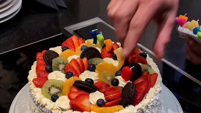 Homemade cake with fruits and candles, joyful mood in Jelgava, Latvia