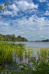 A serene view of the Dnieper River in Kiev, Ukraine showcases calm waters flowing through the city under soft daylight and a clear sky.
