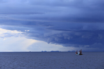 A medium-sized Thai fishing boat is heading into a rainstorm in the Gulf of Thailand, Chumphon...