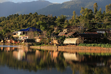 Fototapeta premium Ban Rak Thai (Mae Aw) Beautiful Tranquil Village in Mae Hong Son Province, Thailand, Rak Thai Village reflection in Richpool at Mae Hong Son, Thailand