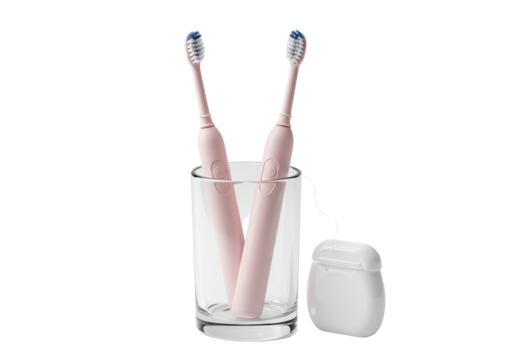 Isolated electric toothbrushes in a cup with dental floss, oral hygiene essentials at home