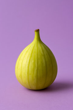 Fresh yellow fig fruit on a pastel purple background