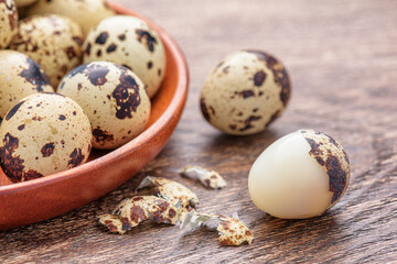 Closeup view of quail eggs in wooden plate on table