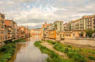 Fototapeta premium Spain - Girona city, day trip from Barcelona. Travel Costa Brava. Tuscany in Spain. Off the beaten path holidays. Colorful houses by river. Spanish cityscape view. Traditional picturesque south Europe