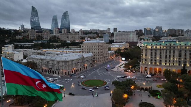 Panoramic View of Baku Cityscape with Waving Azerbaijani Flag and Flame Towers at Dusk