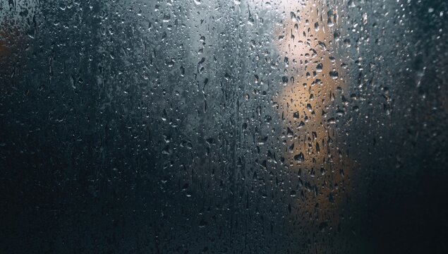 Reflection of rain water flowing on a glass window, seasonal change