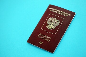 Russian Federation red passport on light blue table background close up. Concept of travel and tourism