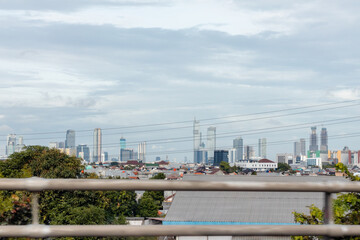 Skyscrapers among residential houses in Jakarta with cloudy sky