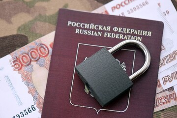 Russian rubles money bills and passport under ban of heavy lockpad close up. Concept of sanctions...