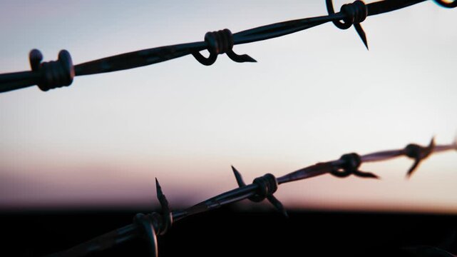 Barbed Wire Silhouette Panning Against Twilight Sky