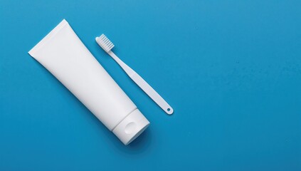 White Plastic Toothpaste Tube and Toothbrush on a Blue Surface, hygiene routine