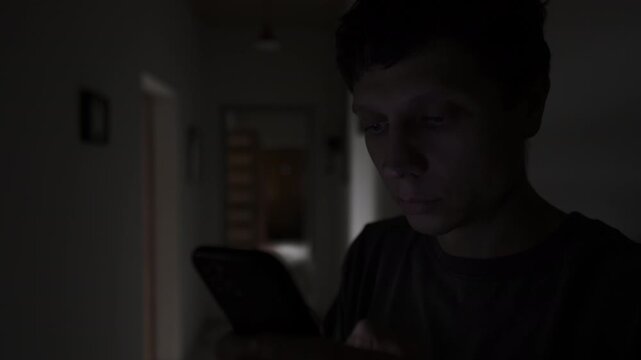 Man secretly texting a lover in a dark hallway, hidden relationship and cheating