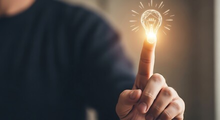 Person touching a glowing light bulb with their finger symbolizing an idea