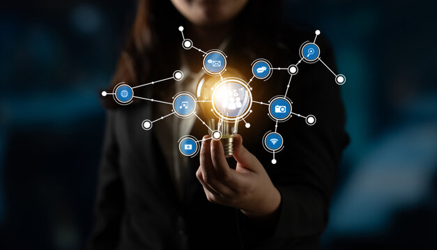 A businesswoman holds a glowing light bulb, symbolizing innovative ideas and technological advancements, surrounded by digital connections representing creativity and inspiration. Tessel