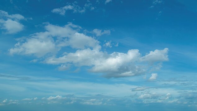 Beautiful azure sky adorned with clouds, ideal backdrop for creative layouts