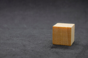 An isolated wooden cube on dark background with customizable space for text or ideas. Copy space concept..
