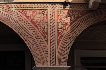 Red Floral Sculpted Decoration on a Building Facade in Udine, Italy
