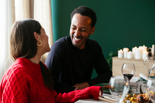 Happy heterosexual couple enjoys dinner party at home