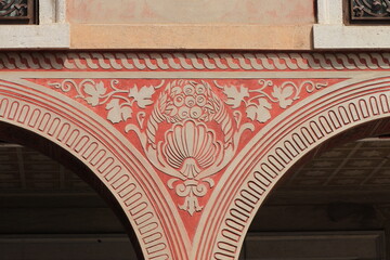 Red Sculpted Decoration on a Building Facade in Udine, Italy