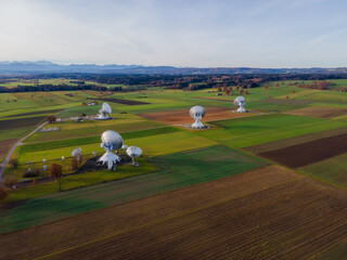 Raisting, Germany - 11 November 2025: Aerial view of the gleaming Raisting Earth Station nestled among patchwork fields, reflecting the soft light of the setting sun.
