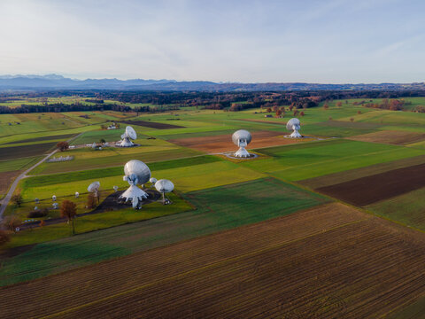 Raisting, Germany - 11 November 2025: Aerial view of the gleaming Raisting Earth Station nestled among patchwork fields, reflecting the soft light of the setting sun.