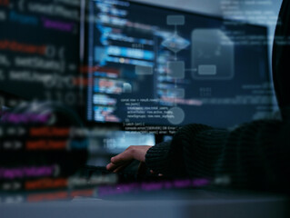 Hacker or Software Developer Typing on Keyboard with Programming Code and Flowchart Algorithm on Screen, Showing Concept of Cybersecurity, Data Analysis, and Modern System Engineering in office night.
