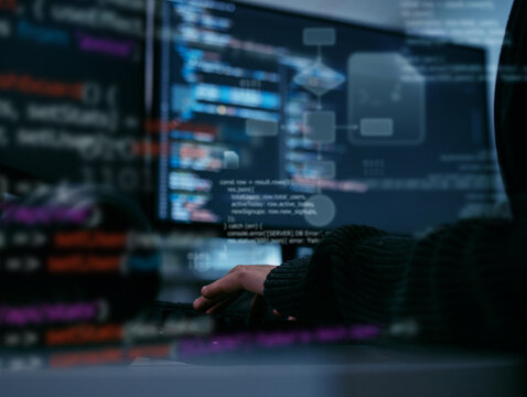 Hacker or Software Developer Typing on Keyboard with Programming Code and Flowchart Algorithm on Screen, Showing Concept of Cybersecurity, Data Analysis, and Modern System Engineering in office night.