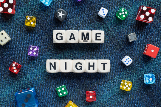 GAME NIGHT spelt using wooden word dice with vibrant dice set over a calming blue tartan background - perfect for promoting game events or fun family gatherings. - Powered by Adobe