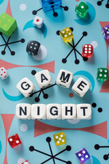 GAME NIGHT spelt using wooden word dice with vibrant dice around set over a playful retro board - perfect for promoting game events or fun family gatherings.