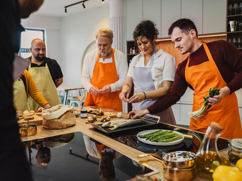 Friends enjoying a cooking class together in a modern kitchen