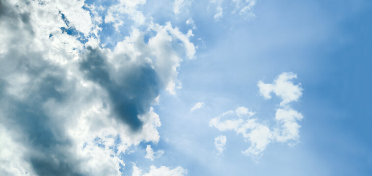 The sun behind the clouds in the blue sky. Natural background