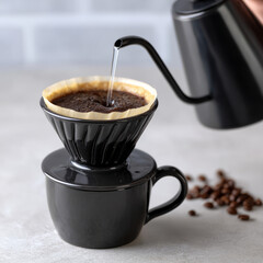 Pour over coffee brewing in black ceramic cup.
